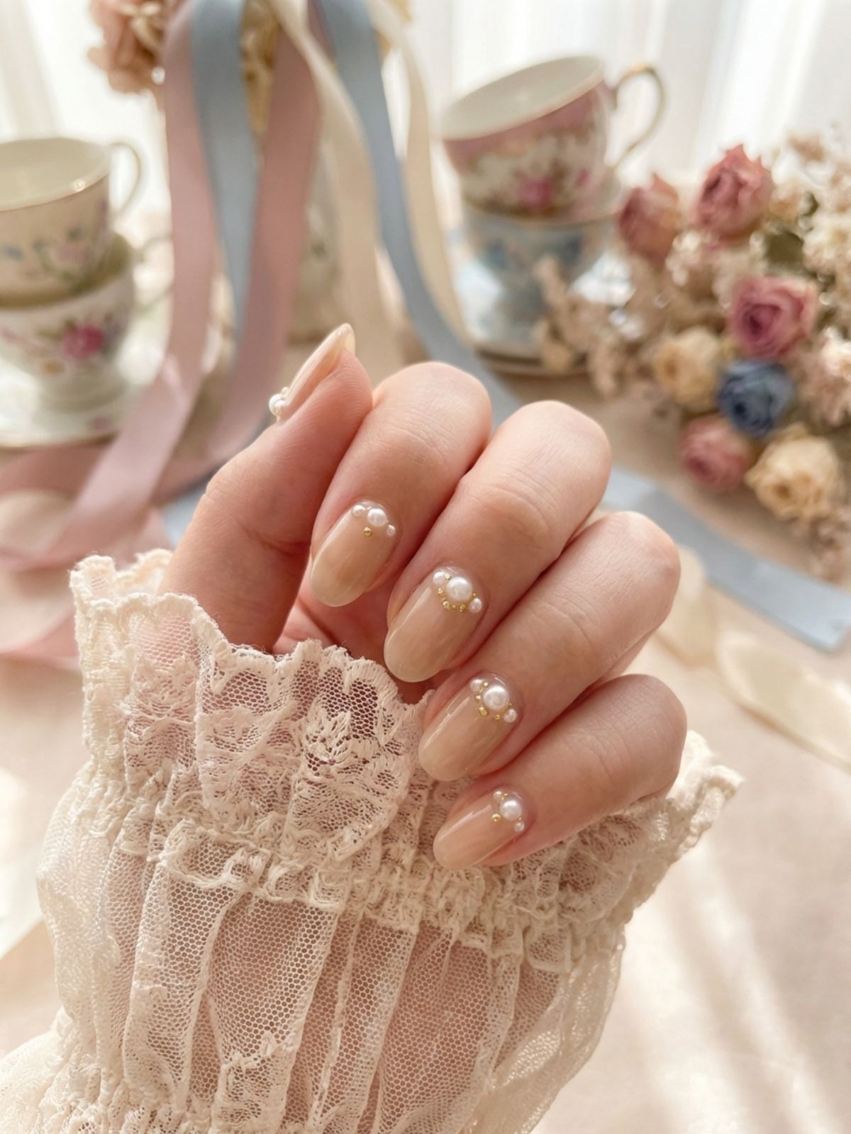 Elegant sheer beige nails decorated with delicate pearl accents. Beige and Milky White Nail Ideas - Elegant sheer beige nails decorated with delicate pearl accents.