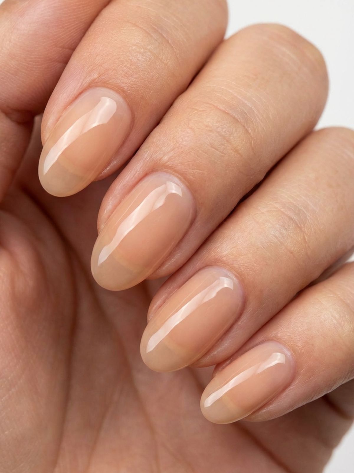 Minimal Nails for Wedding Guests - The lip gloss manicure uses sheer peach tones and high shine to warm up your skin tone.